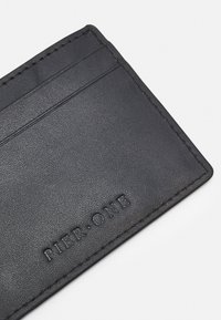 Black leather cardholder with textured surface, featuring multiple card slots and embossed "PIER·ONE" branding along the bottom edge.