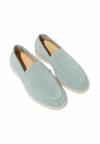 Mocassini in suede verde menta con una texture liscia, punta arrotondata e dettagli di cucitura sottili. La suola beige morbida completa il design.