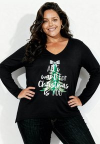 Czarna koszula z długim rękawem i dekoltem w serek, z grafiką choinki i napisem, wykonana z miękkiego materiału o luźnym kroju.