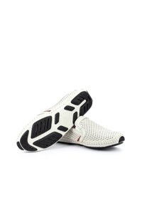 Hvide slip-on sko med perforeret overdel, røde syninger og strukturerede sorte gummisåler. Rund tådesign, letvægtsmateriale.