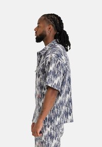 Korte mouwen overhemd in blauw-witte patroon, met een kraag en een loose fit, gemaakt van een geweven stof.