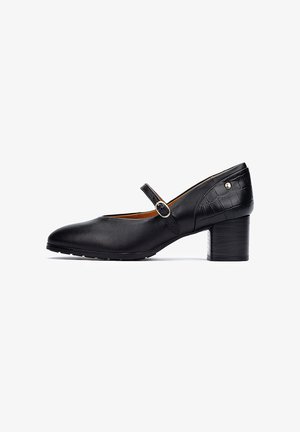 Chaussure Mary Jane en cuir noir avec un bout rond, une sangle de cheville avec une boucle ronde et un talon en bois de hauteur moyenne. Accents texturés sur le talon.