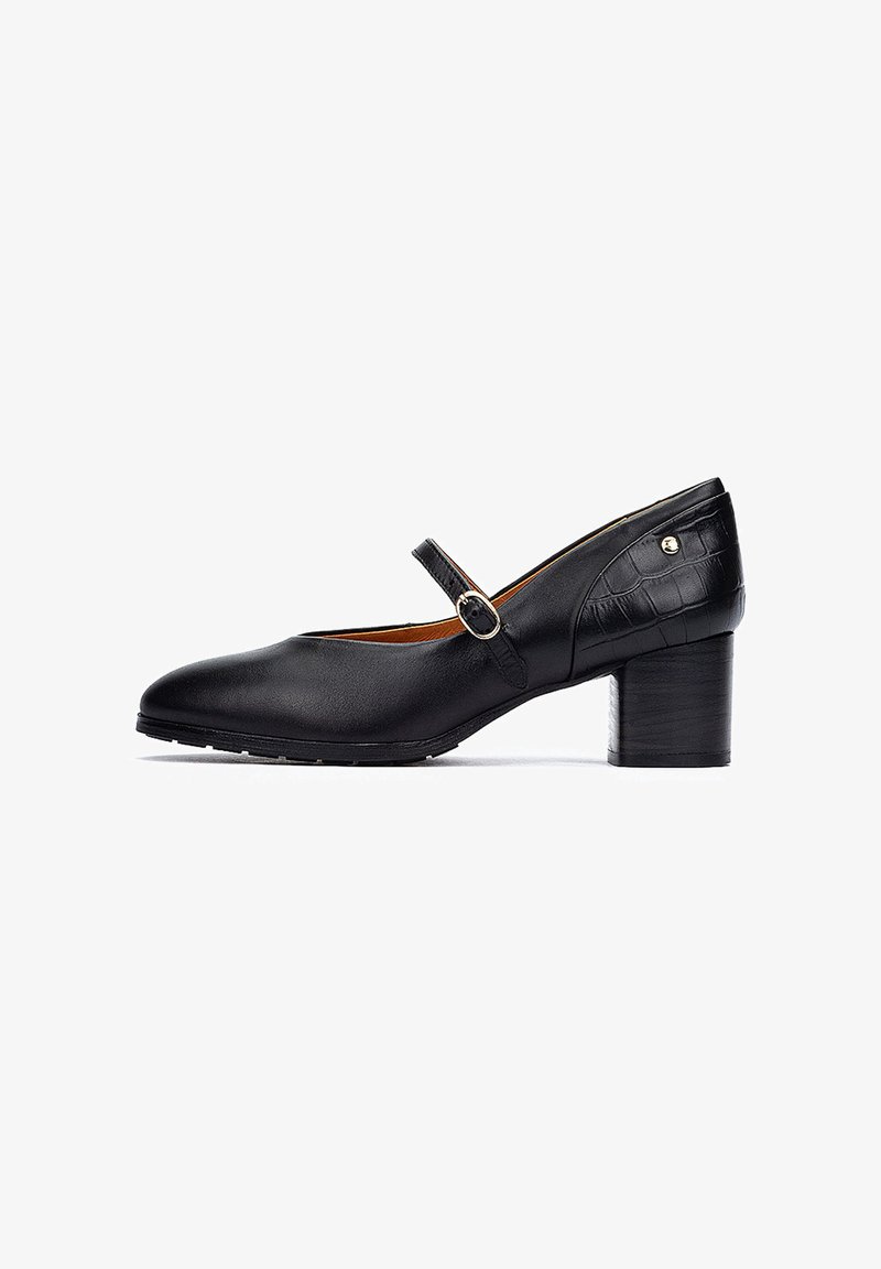 Scarpa Mary Jane in pelle nera con punta arrotondata, cinturino alla caviglia con fibbia tonda e tacco in legno di media altezza. Dettagli testurizzati sul tacco.
