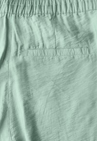 Shorts vert menthe avec une texture douce et lisse, dotés d'une taille élastique et d'une poche plaquée à l'arrière.