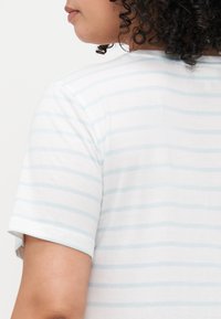 Lengvas, trumpomis rankovėmis T-shirt su apvaliu kaklu, su plonomis šviesiai mėlynomis juostelėmis ant balto fono. Minkšta medvilnės struktūra.