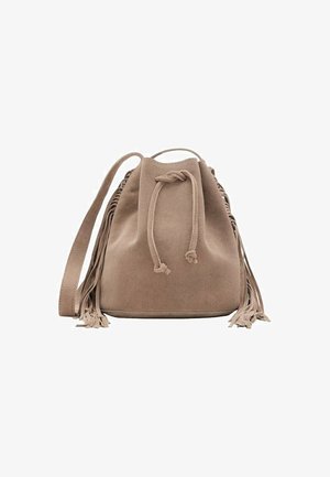 Sac seau en suédine beige avec un fermeture à cordon, une sangle réglable et de longs franges sur les côtés. Texture lisse et base ronde.