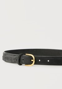 Cinturón de cuero negro con textura lisa y hebilla de metal en tono dorado, colocado plano sobre un fondo blanco.