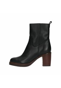 Stivale alla caviglia in pelle nera con punta rotonda e tacco a blocco di altezza media. Presenta un design semplice con cuciture minime e una linguetta per facilitare la calzata.