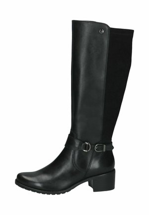 Black knee-high leather boot with low block heel and decorative strap with silver buckle around the ankle.