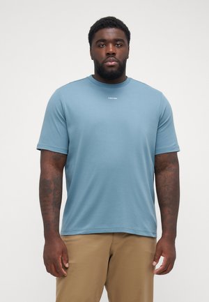 Lühikeste varrukatega sinine puuvillane T-särk, ümmarguse kaelusega ja väikese valge "Calvin Klein" logo'ga rinna peal, sile tekstuur. Üksik mugavus.