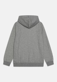 Hoodie gris en molleton doux et texturé. Il présente une grande capuche, des manches longues, ainsi que des poignets et un ourlet côtelés. Pas d'ornements.