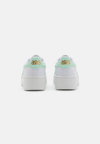 White sneakers with a mint green back, featuring a smooth texture, raised white midsole, and gold ASICS logo at the heel.