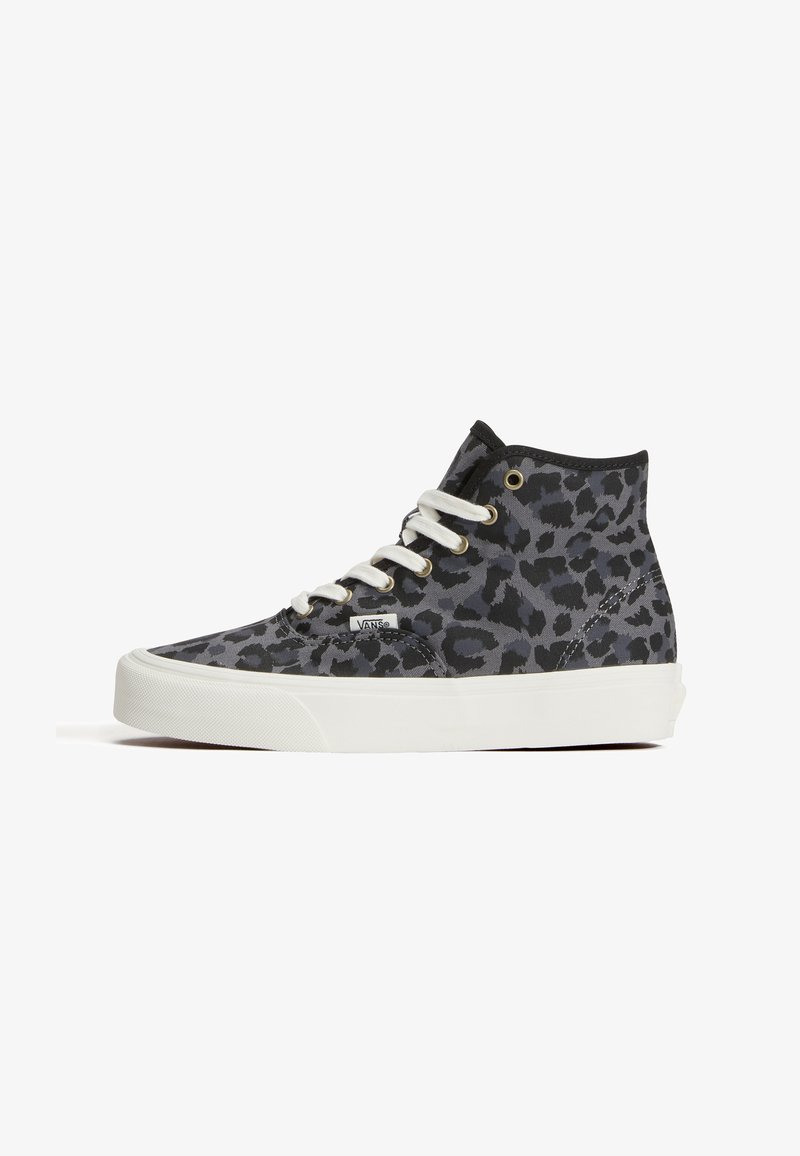 Висок спортен обувка Vans с черен и тъмно сив леопардов принт, бели връзки и дебела бяла подметка, показана отстрани на бял фон.