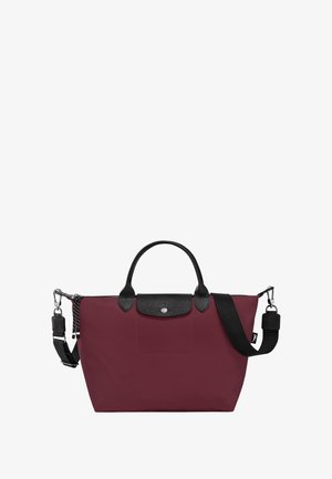 Maroon tote bag made of durable nylon, featuring black leather accents, dual handles, and an adjustable shoulder strap. Silver hardware detail.