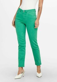Green denim jeans with a slim fit, featuring a mid-rise waist, front pockets, and a zip fly closure. Smooth texture with a solid finish.