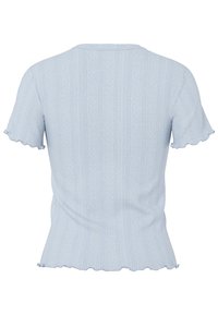 Lyseblå strikket topp med et teksturert mønster, bølgete korte ermer og en tettsittende fasong. Bakfra viser den sømmen og subtil detailing.
