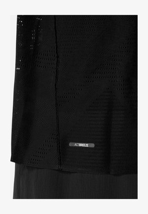 Tela de malla negra transpirable con un patrón texturizado. Presenta costuras cosidas y una etiqueta de tela que dice "ACTIBREEZE" cerca de la parte inferior.