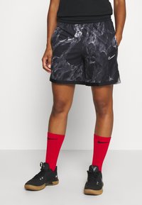 Nike black and gray patterned shorts with an elastic waistband, side pockets, and contrasting black hem. Paired with red socks and black shoes.