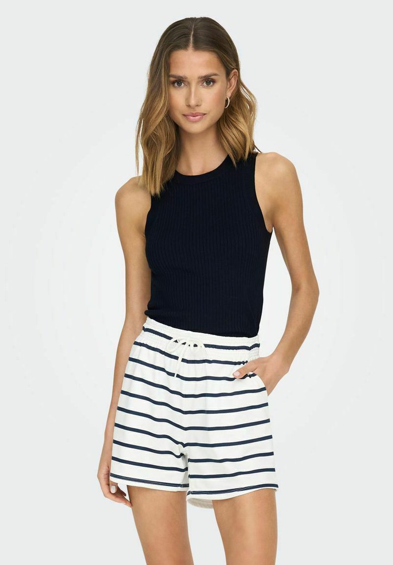 Camiseta de tirantes con canalé en color navy, combinada con pantalones cortos blancos que presentan rayas horizontales en navy y una cintura elástica con cordón.