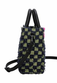 Sac fourre-tout avec un motif à damier noir et vert, fabriqué en tissu texturé aux bords effilochés. Dispose de poignées en cuir noir et d'une bandoulière réglable.