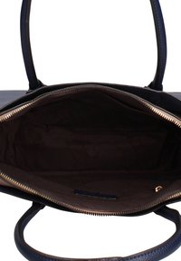 Marineblauwe lederen handtas met een gestructureerde buitenkant, voorzien van een ritssluiting en een zachte bruine binnenkant. Dubbele handvatten om te dragen.