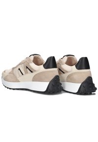 Beige and tan sneaker with suede and mesh upper, black accents on heel, and white midsole. Notable textured black rubber outsole.