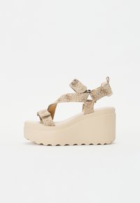 Plattform Sandalen mit einem beigen, strukturierten Obermaterial, überkreuzten Riemen und einer dicken, klobigen Keilsohle mit gerilltem Rand.