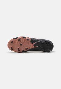 Suola di scarpa sportiva nera con parte superiore texturizzata, caratterizzata da una suola esterna fucsia vivace e da nubi di trazione esagonali per una presa migliore.