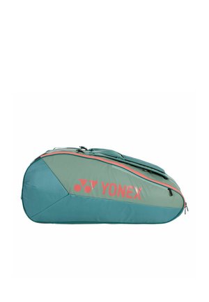 Sac de sport Yonex vert et bleu sarcelle avec logo rouge et fermeture éclair, conçu pour contenir des raquettes de badminton ou de tennis, posé à plat sur un fond blanc.