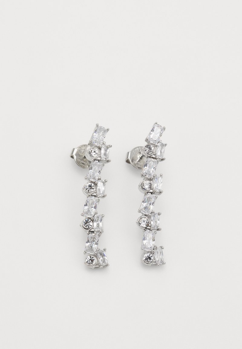 Hõbedatooni kõrvarõngad, millel on vertikaalne disain ja selged ristküliku- ja ümmargused kristallid, millel on vahelduvad kujundid ja suurused.