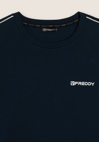 T-shirt in cotone blu navy con colletto rotondo, caratterizzato da strisce decorative bianche sulle maniche e un piccolo logo bianco sul petto.