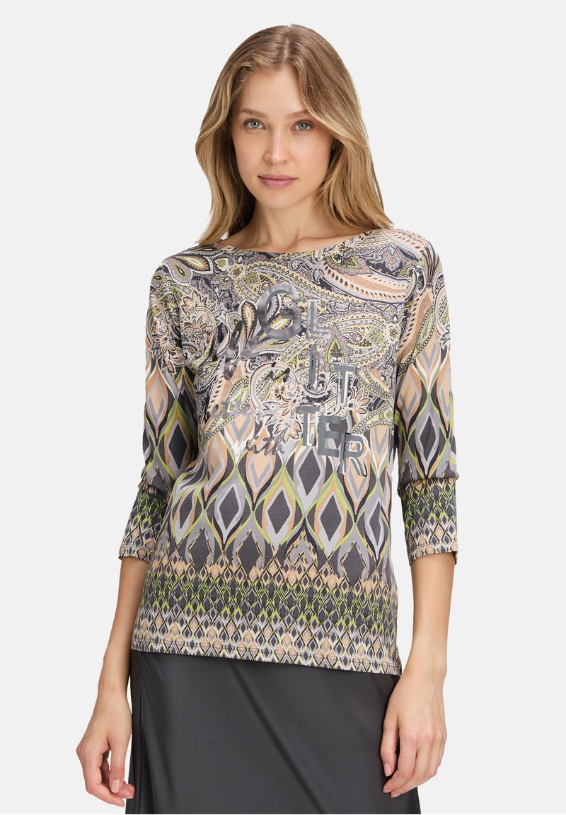 Multicolored long-sleeve top featuring a paisley pattern, geometric designs, and metallic text detail, with a soft, smooth fabric texture.