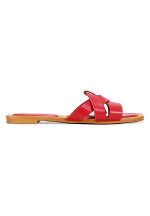 Sandalias de deslizamiento de cuero rojo con un diseño de tiras cruzadas, suela plana y detalles en color tostado en la suela para contraste. Textura suave en general.