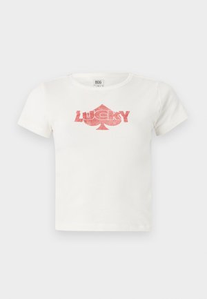 White cotton t-shirt with short sleeves featuring a pink glitter graphic of the word "LUCKY" and a spade shape underneath.