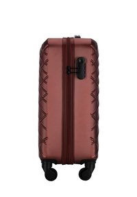 Hard-shell suitcase in dark red with a textured surface, featuring a zipper closure, side handle, and four swivel wheels for mobility.