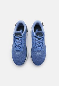 Zili zili Nike sporta apavi ar teksturētu sietiņu augšdaļu, noapaļotu formu un atbilstošām šņorēm. Ievaidas ar GORE-TEX zīmolu un apļveida akcentiem sānos.