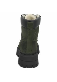 Stivale in suede verde con un colletto in pelle nera, dotato di una parte superiore imbottita, suola in gomma resistente e linguetta sul tallone per una facile vestibilità.