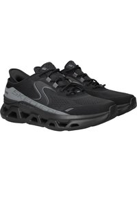 Scarpe da ginnastica nere con tomaia in rete testurizzata, intersuola ammortizzata e suola in gomma prominente caratterizzata da un design intagliato e dettagli grigi.