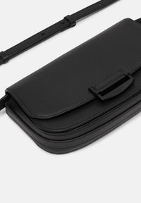 Borsa a tracolla in pelle nera con chiusura a pattina, forma rettangolare, superficie liscia e tracolla regolabile con dettagli in metallo.