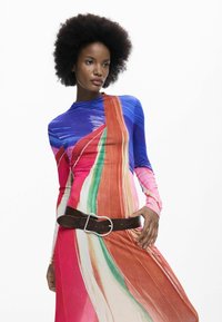 Hosszú ujjú, többszínű ruha élénk kék, piros, zöld és rózsaszín csíkokkal. Barna övvel, ezüst csattal.