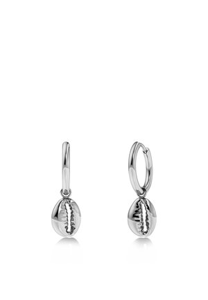 Boucles d'oreilles créoles en argent avec de petits charms polis en forme de coquillages cauris suspendus à chaque créole sur fond blanc.