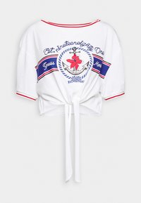 T-shirt blanc court avec des accents rayés rouges et bleus, présentant un graphique d'ancre florale et un détail de tie knot à l'ourlet.