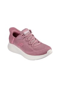Zapatilla deportiva de color rosa claro con parte superior de tejido transpirable, diseño con cordones, cuello acolchado y suela blanca acolchada. Presenta detalles texturizados.