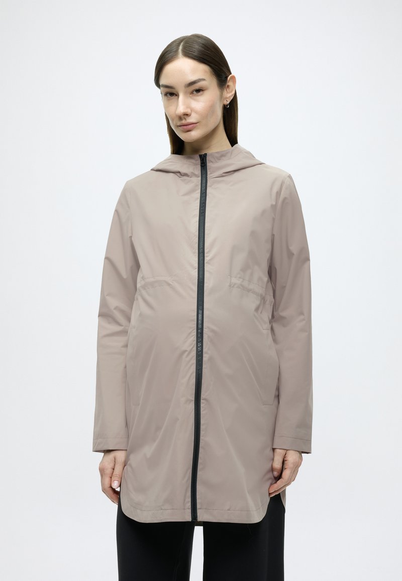 Ελαφρύ μπεζ αδιάβροχο μπουφάν με κουκούλα, πλήρες φερμουάρ μπροστά και πλαϊνές τσέπες. Διαθέτει κομψή σχεδίαση και απαλή υφή.