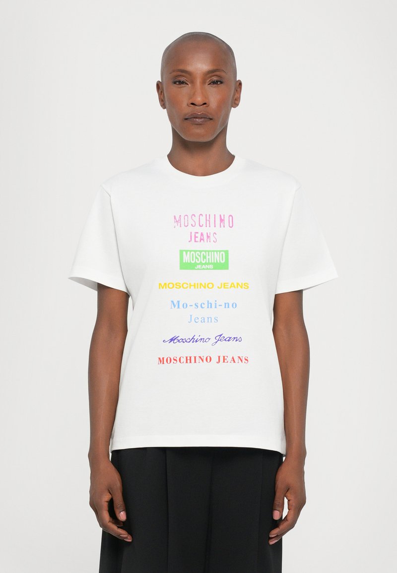 White t-shirt featuring multi-colored "MOSCHINO JEANS" text in varying fonts, short sleeves, and a crew neck. Smooth fabric texture.