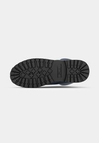 Semelle extérieure en caoutchouc noir avec motif de relief texturé ; présente un logo et des accents. La conception comprend des rainures profondes pour une meilleure traction et durabilité.