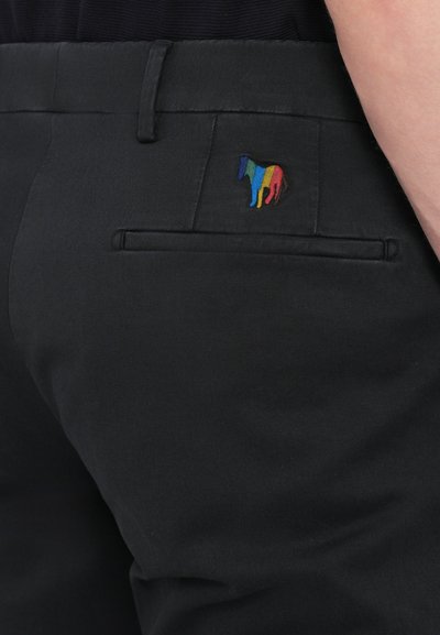 Pantalons noirs avec une texture lisse, dotés d'une poche arrière et d'un petit logo de cheval brodé coloré. Design simple et ajusté.