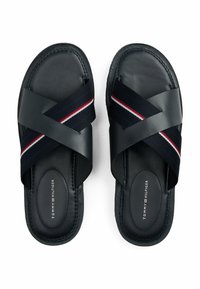 Sandali slip-on in pelle blu navy con cinturini incrociati in tessuto con righe rosse, bianche e blu. Suola piatta, soletta con marchio.