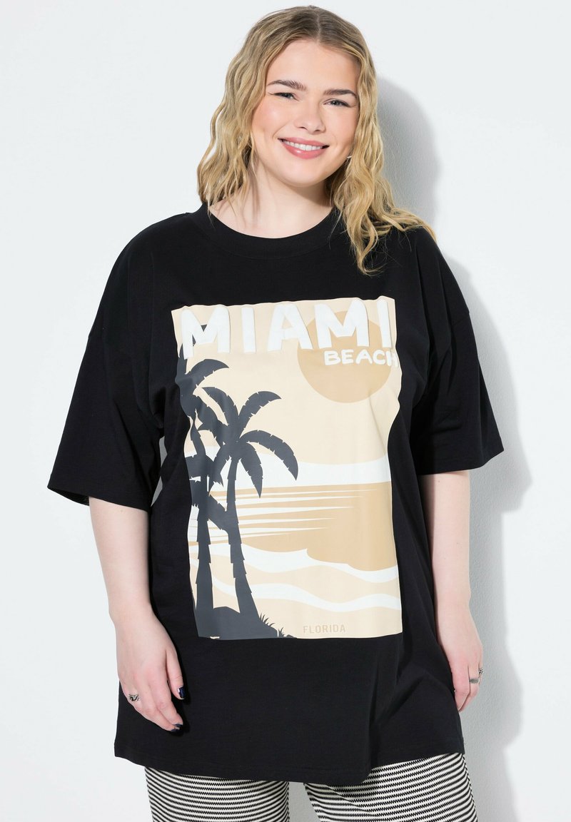 Mustat ylisuuret T-paidat, joissa on graafinen printti palmupuista ja auringonlaskusta sekä teksti "MIAMI BEACH" valkoisissa ja beigen sävyissä.