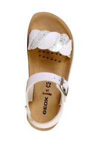 Sandale blanche avec des brides torsadées en argent et blanc, boucle ajustable, semelle intérieure texturée en liège et semelle externe perforée. Marque : GEOX.